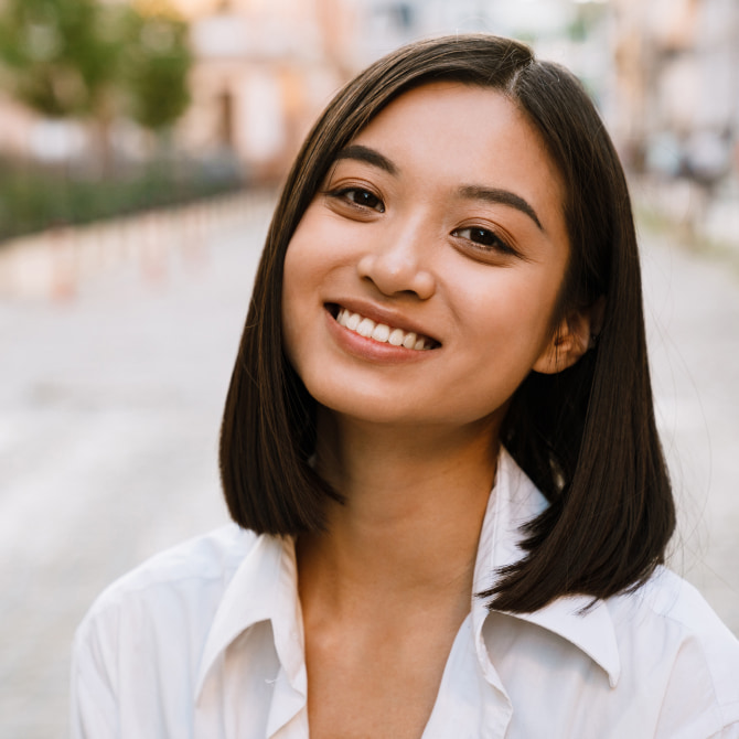 Photo of a smiling woman in white shirt