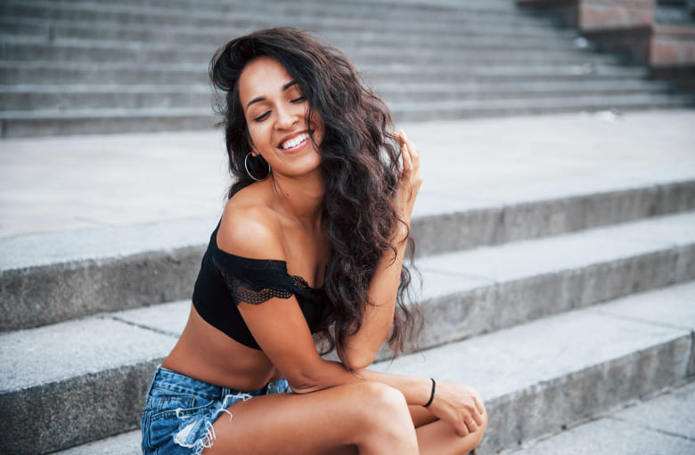 Photo of young woman smiling while sitting on the stairs