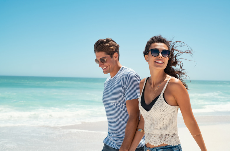 Enhance Your Appearance with Juvéderm A couple smiling while walking on the beach