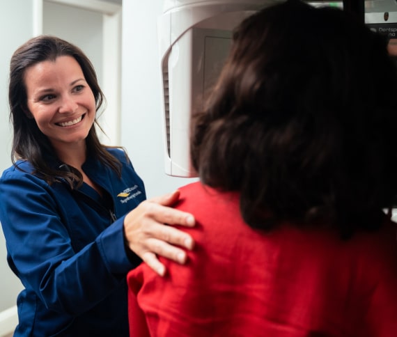 A photo of our team member helping patient make procedure inside Axios system