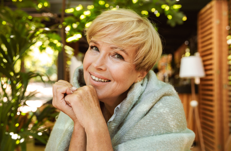 Adult woman smiling while sitting in the garden