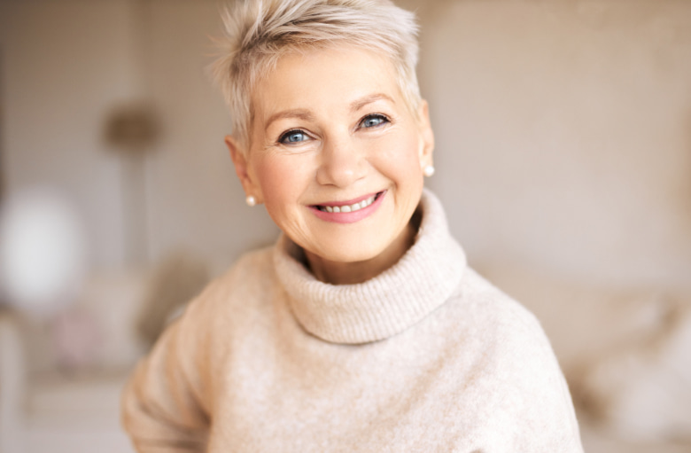 Adult woman with light hair is happily smiling