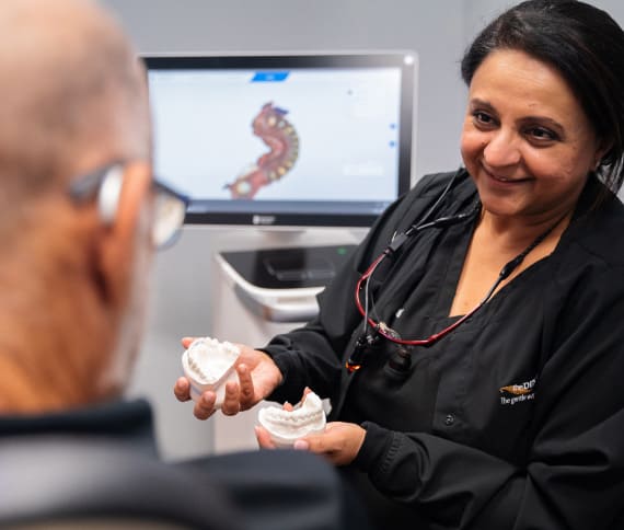Doctor showing to patient models of jaws