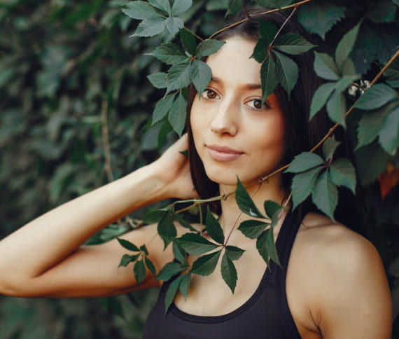 Girl is smiling while standing near green wall