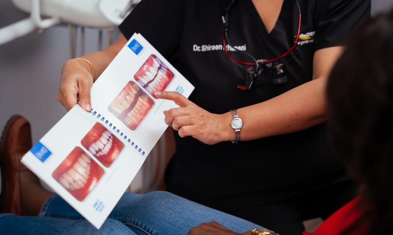 Patient and doctor look at before and after photo of teeth whitening