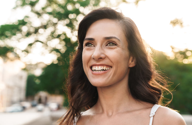 Woman happily smiling while walking in the park