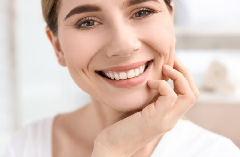 Woman is smiling while take her hand to the head
