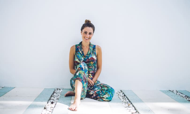 Woman smiling while sitting near wall