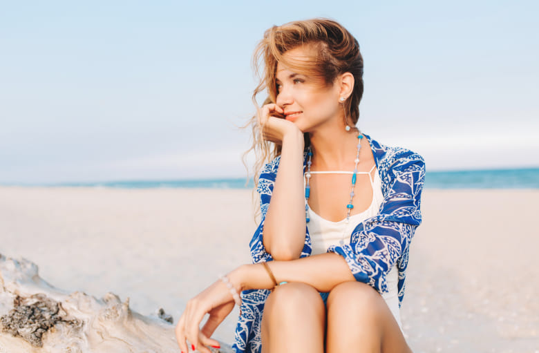 Exosome Therapy for Hair Loss Woman smiling while sitting on the beach