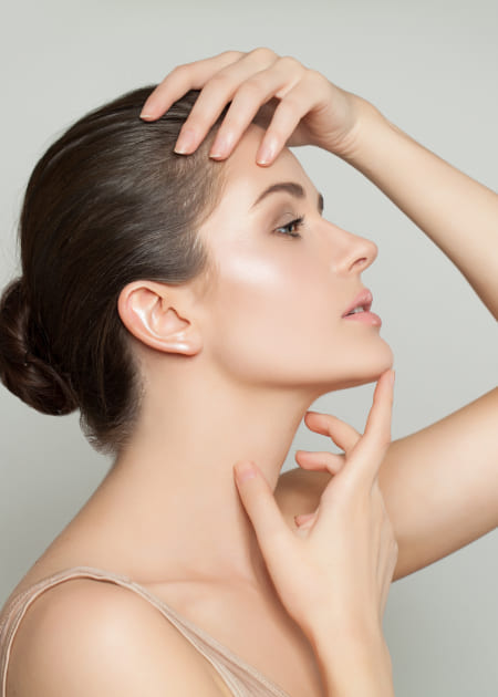 Woman with dark hair take her hands to her head